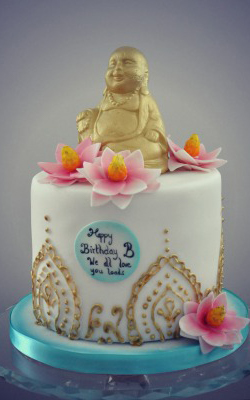 gold buddha sitting on top of a cake