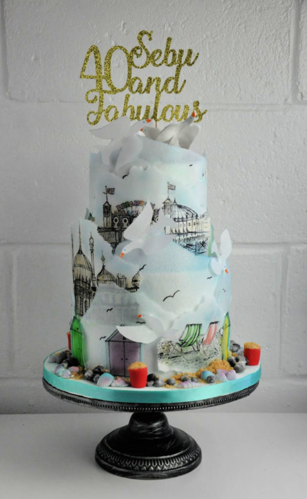 two tier brighton-themed cake with rice paper hand painted drawings on it