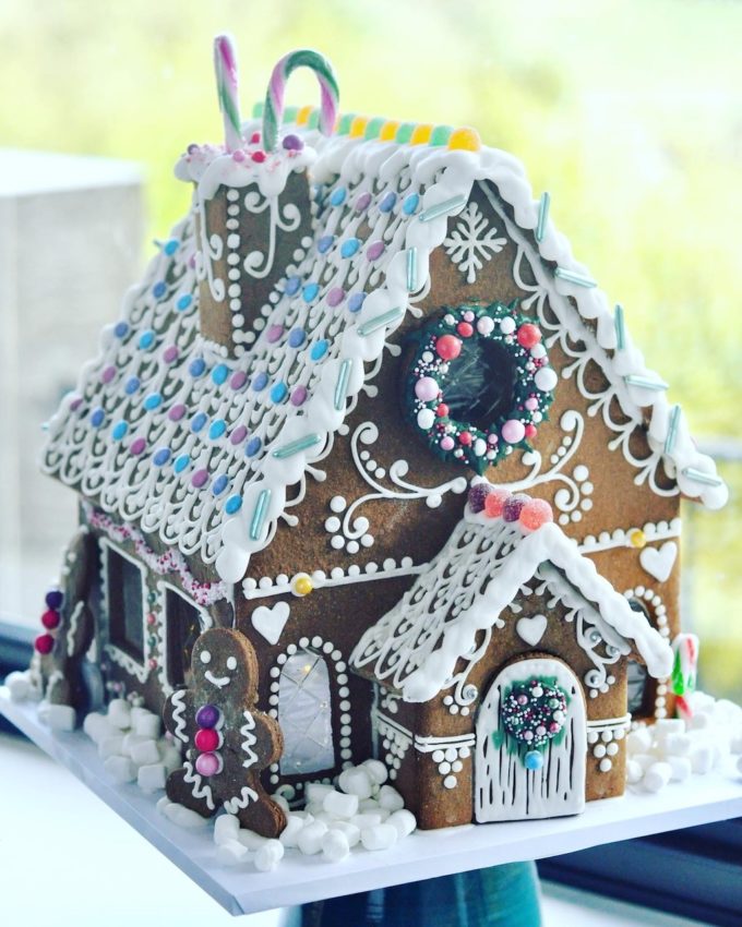large gingerbread house with a porch and ginegrbread snowmen