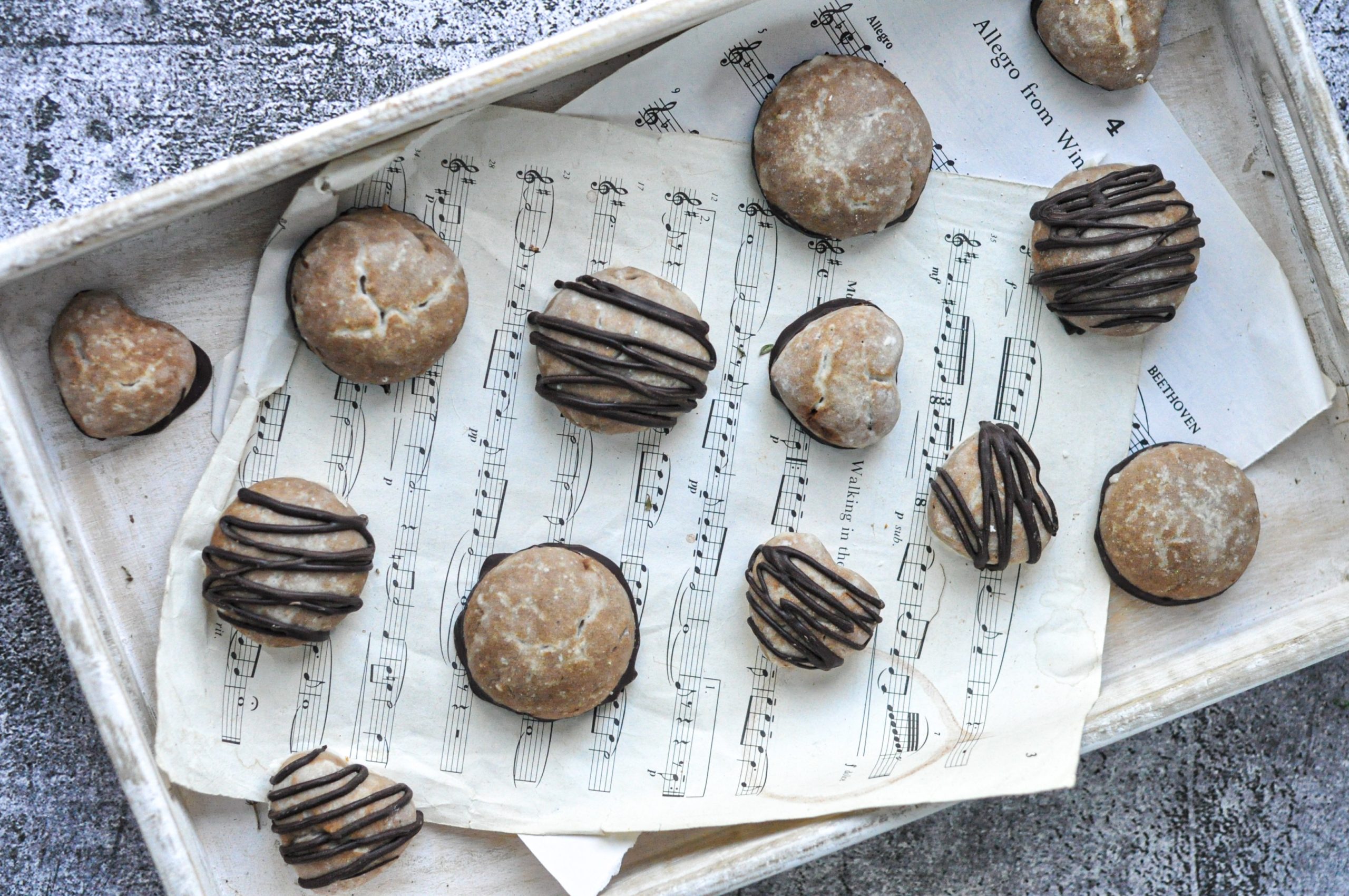 lebkuchen soft biscuits arranged on sheets of music in a tray