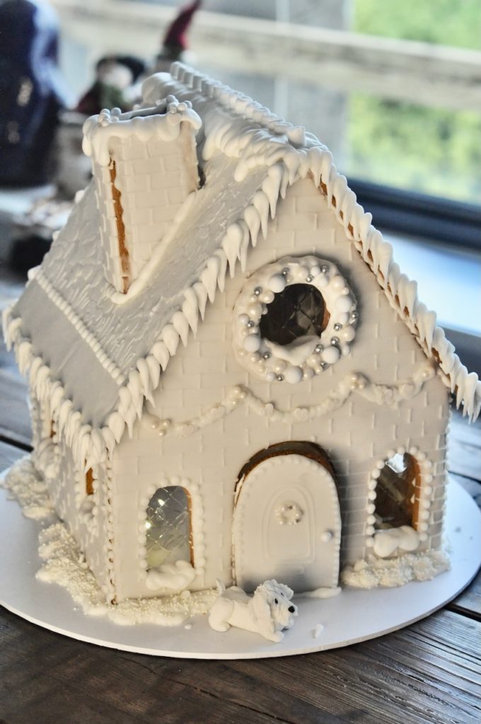 An all white gingerbread house with white chocolate decorations