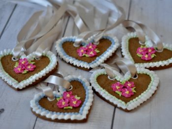 lebkuchen heart biscuist deocrated with royal icing pink roses and ribbons